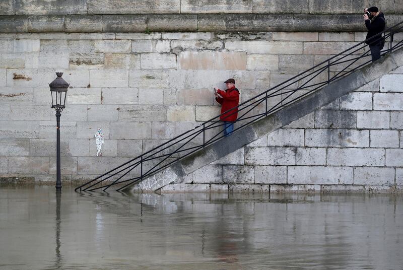 Men take pictures of a street lamp on the flooded banks of the River Seine in Paris, France, after days of almost non-stop rain caused flooding in the country. Christian Hartmann / Reuters