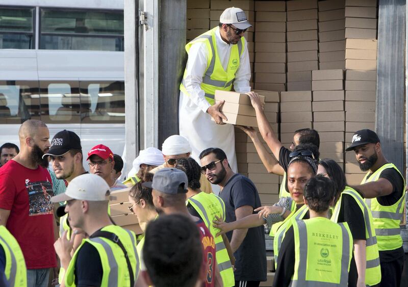 DUBAI, UNITED ARAB EMIRATES -  Boxes of iftar meal being distributed to the volunteers to be place where workers will break their fast. Dubai Police join hands with Berkeley Assets to serve up Iftar dinner to mark Laylatul Qadr for 10,000 labourers with seating for 5,000 and another 5,000 laborers will go home with meal boxes in Al Muhaisnah, Dubai.  Ruel Pableo for The National