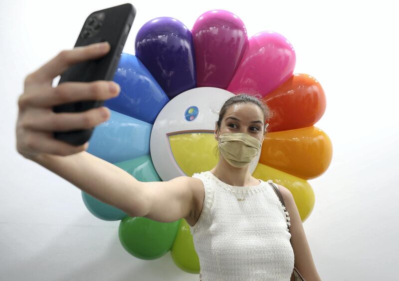 Dubai, United Arab Emirates - Reporter: Alexandra Chaves. Arts and Lifestyle. A visitor takes a picture in the Perrotin section with a piece of artwork by Takashi Murakami. Art Dubai 2021 opens at the DIFC. Tuesday, March 30th, 2021. Dubai. Chris Whiteoak / The National
