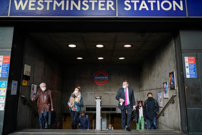 People wear face masks as they exit Westminster underground station in London. AP Photo
