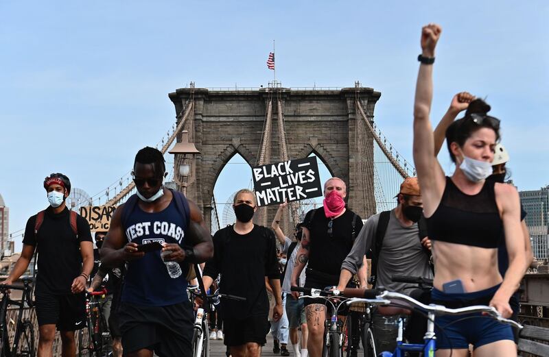 TOPSHOT - Protesters gather to demonstrate the death of George Floyd on June 4, 2020 on top of the Brooklyn Bridge in New York. On May 25, 2020, Floyd, a 46-year-old black man suspected of passing a counterfeit $20 bill, died in Minneapolis after Derek Chauvin, a white police officer, pressed his knee to Floyd's neck for almost nine minutes. / AFP / Angela Weiss
