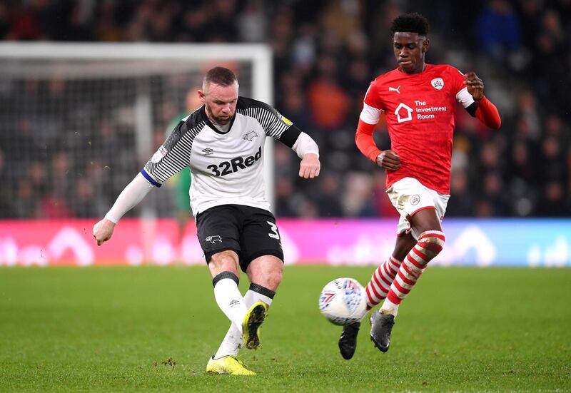 Wayne Rooney passes the ball under pressure from Elliot Simoes of Barnsley. Getty