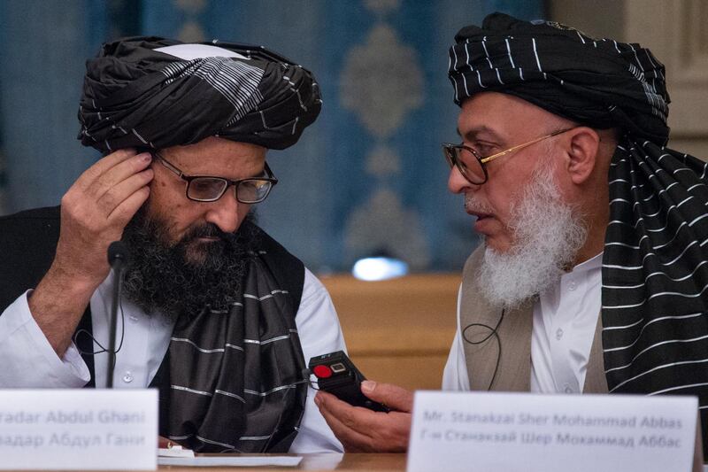 FILE - In this May 28, 2019 file photo, Mullah Abdul Ghani Baradar, the Taliban group's top political leader, left, and Sher Mohammad Abbas Stanikzai, the Taliban's chief negotiator, talk to each other during a meeting in Moscow, Russia. Afghanistanâ€™s Taliban leaders agreed they wanted a deal with the United States, but some among them were in more of a hurry than others. Even before U.S. President Donald Trump cancelled a mysterious Camp David summit on Saturday, Sept. 7, 2019, the Taliban negotiators were at odds with the council of leaders, or shura, that rules the Islamic movement. (AP Photo/Alexander Zemlianichenko, File)