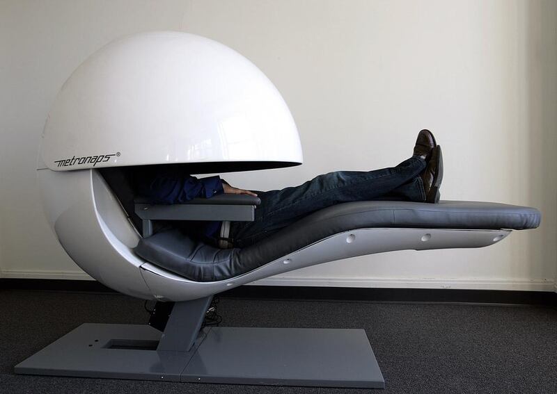 Metronaps CEO Arshad Chowdhury demostrates a prototype sleeping "pod" with a retractable shield that covers the upper body. Photo: Stan Honda / AFP