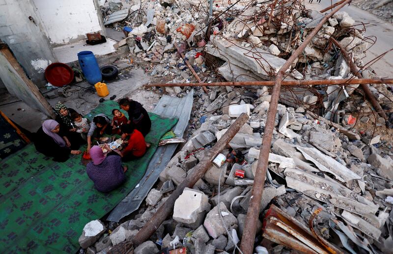 A family end their fast amid the rubble of their destroyed home, during Ramadan in Rafah, in March. Reuters