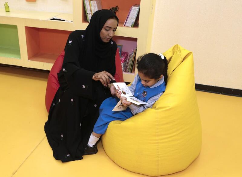 Teacher Najat Darwish Ali helps eight-year-old Nadha Al Naqbi, who is autistic, with her reading at Fujairah Rehabilitation Centre. Jeffrey E Biteng / The National