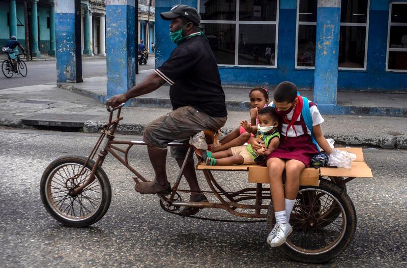 A man transports children on his tricycle, in Havana, Cuba. AP Photo