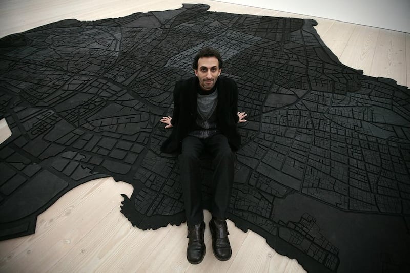 The Lebanese artist Marwan Rechmaoui with his work Beirut Caoutchouc, a map of Beirut consisting of 60 interlocking pieces of rubber. Shaun Curry / AFP

