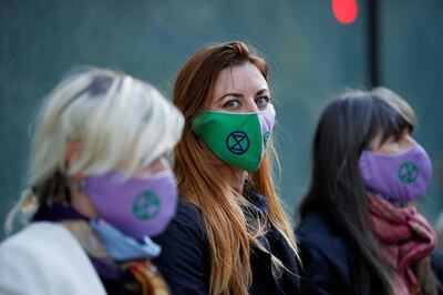 Activists from the Extinction Rebellion, a global environmental movement, wear masks during a direct action protest, at HSBC headquarters in Canary Wharf, London, Britain April 22, 2021. REUTERS/John Sibley