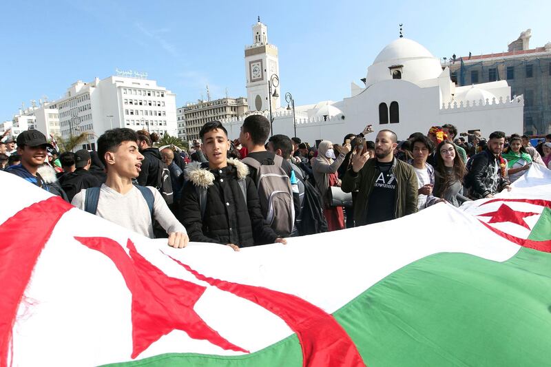 High school students march with a huge national flag in central Algiers, Sunday, March 10, 2019. The protesters are challenging President Abdelaziz Bouteflika's fitness to run for a fifth term in next month's election. (AP Photo/Anis Belghoul)