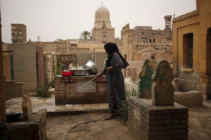 A woman cleans a tomb outside her home in the Cairo Necropolis, known as the City of the Dead, on October 23, 2015. Asmaa Waguih/Reuters