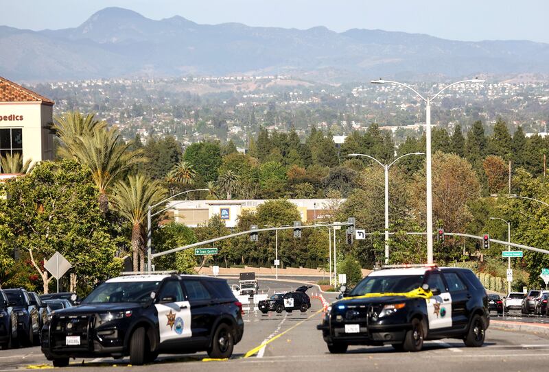 Police vehicles are parked near the scene of the shooting in which at least one person was killed. AFP