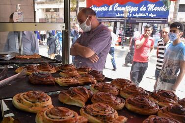 Algerian customers buy pastries in the capital, Algiers, as authorities lift some of the restrictions put in place in a bid to fight the spread of the novel coronavirus. AFP