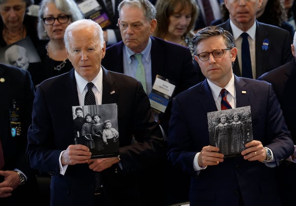 Mr Biden and Speaker of the House Mike Johnson hold photos of victims of the Holocaust during a Holocaust memorial ceremony. Getty Images / AFP