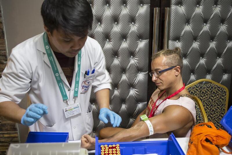 Luca Bottino, an Italian restaurant manager and first-time competitor who lives in Dubai, gives blood ahead of the International Natural Bodybuilding Association championships. Antonie Robertson/The National