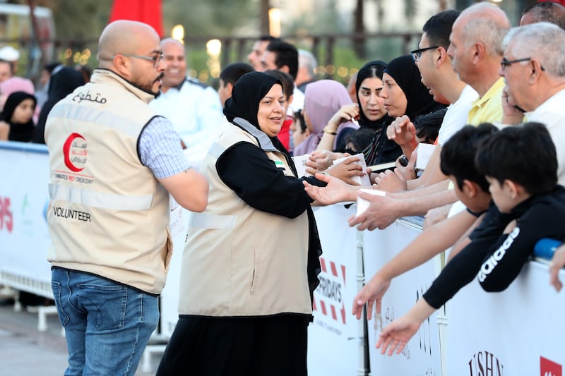 Emirates Red Crescent members distribute dates and water at the Al Majaz waterfront in Sharjah. Pawan Singh / The National