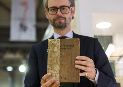 Ben Houston, sales director of Peter Harrington, holding a rare copy of 'In Mutationes Aeris' by French astrologer Firmin de Beauval, which is considered one of the earliest printed collections of weather prediction. Ruel Pableo / The National