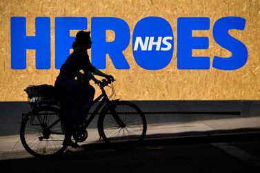 GLASGOW, SCOTLAND - MAY 06: A woman cycles past a sign of support for the NHS during the coronavirus lockdown on May 6, 2020 in Glasgow, Scotland.  The country continues quarantine measures intended to curb the spread of Covid-19, but the infection rate is falling, and government officials are discussing the terms under which it would ease the lockdown. (Photo by Jeff J Mitchell/Getty Images)