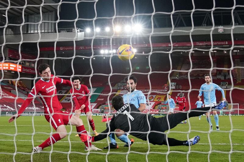 City's German midfielder Ilkay Gundogan scores past Liverpool goalkeeper Alisson Becker. AFP