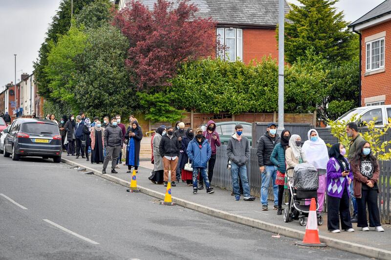 Members of the public queue to receive vaccinations in a pop-up vaccination bus parked at Essa Academy in the Daubhill area of Bolton, north-west England. Bloomberg
