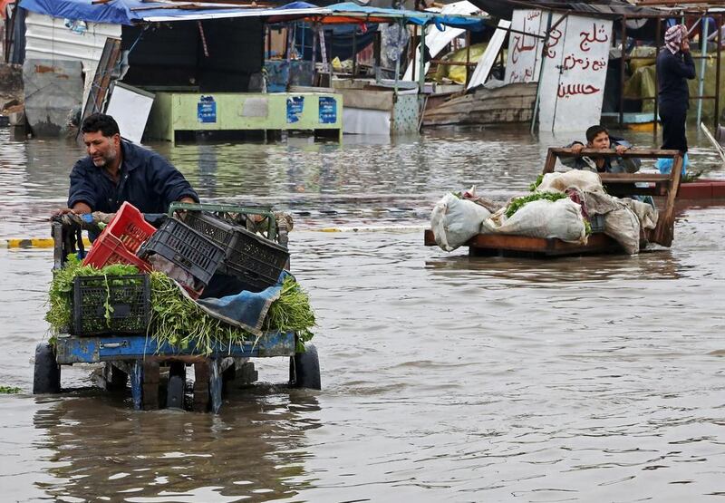 Street vendors make their way through a flooded street after heavy rain fell in Baghdad, Iraq on Wednesday. Karim Kadim / AP

