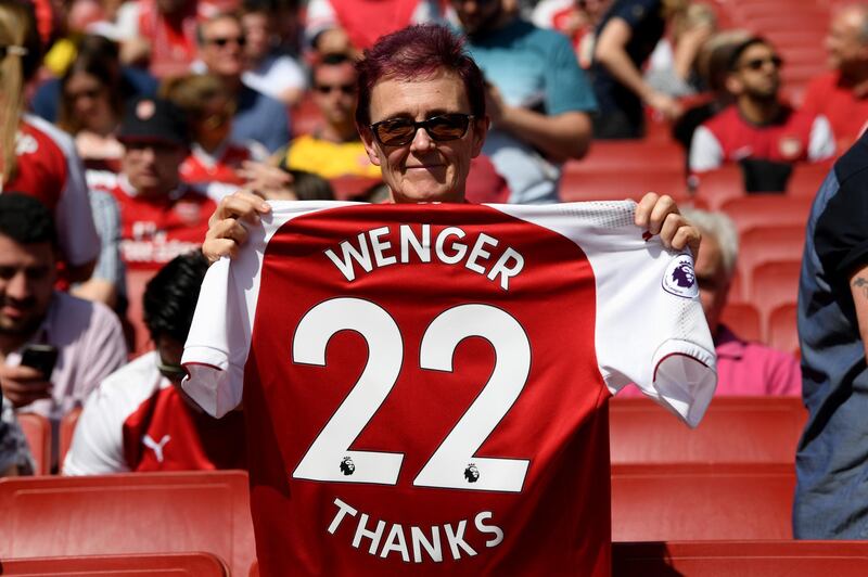 A fan poses with an Arsenal shirt, displaying text to thank Arsene Wenger during the Premier League match between Arsenal and West Ham United at Emirates Stadium on April 22, 2018. Shaun Botterill / Getty Images