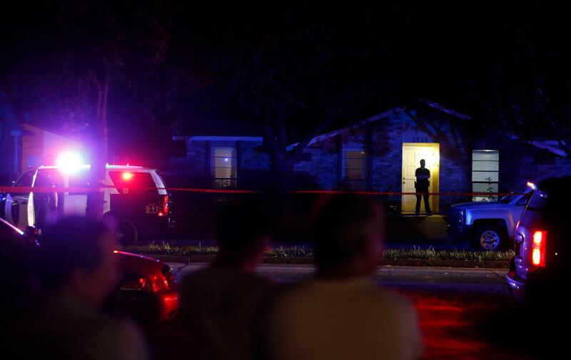 Onlookers watch police work the scene of a shooting at a home in Plano, north of Dallas, Texas, Sunday night, Sept. 10, 2017. Authorities in North Texas say several people are dead, including the suspect, after a shooting at the Plano home. (Vernon Bryant/The Dallas Morning News via AP)