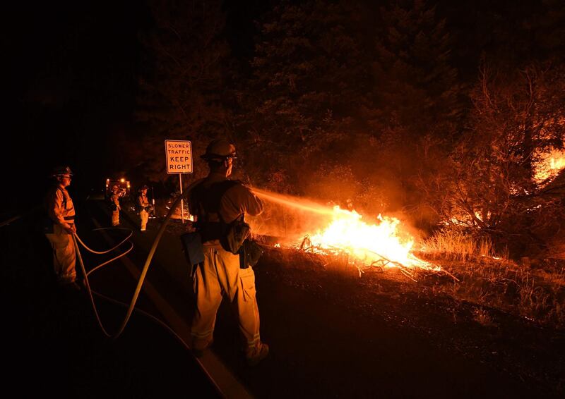 Firefighter Shawn Lee (R) from the Lake Forest unit and his colleagues try to contain flames from the Carr fire as it spreads towards the town of Douglas City near Redding, California. AFP PHOTO / Mark RALSTON