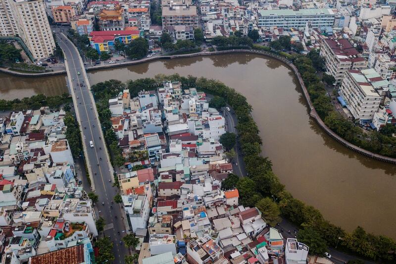 TOPSHOT - This aerial photo taken on October 19, 2018 shows houses along the Xuyen Tam canal in Ho Chi Minh City. There are about 20,000 remaining households on Ho Chi Minh City's serpentine waterways slated to be demolished by 2020 as part of the city's massive renewal project that promises to replace some of the polluted canal banks with Parisian-style riverside promenades, paved roads, modern shops and buildings.  / AFP / Kao NGUYEN
