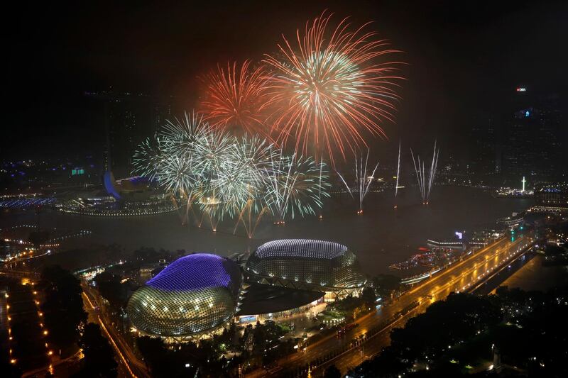 Fireworks explode above Singapore's financial district at the stroke of midnight to mark the New Year's celebrations. Wong Maye-E / AP Photo