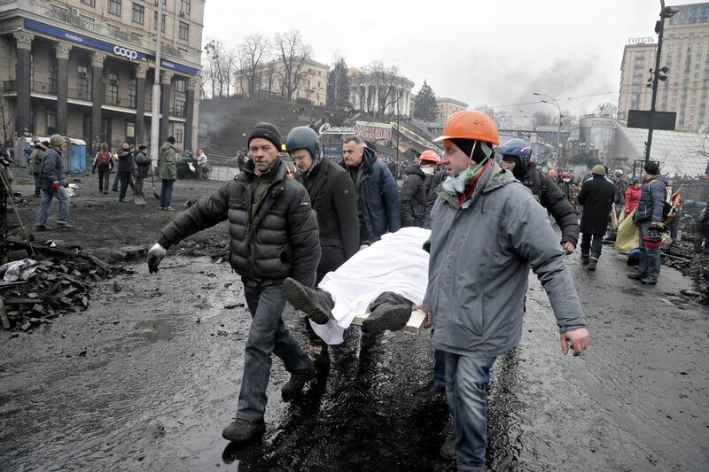 Activists carry a dead protester during clashes with police. Fierce clashes between police and protesters, some including gunfire, shattered a brief truce, killing numerous people. Efrem Lukatsky / AP photo