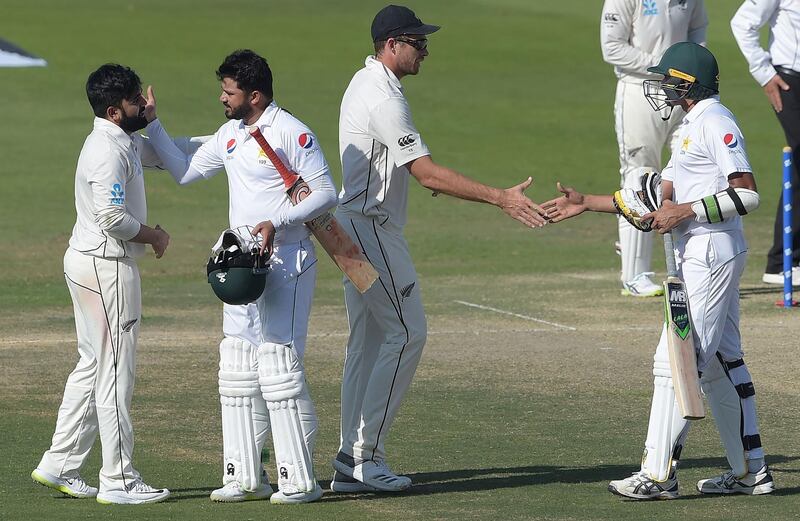Pakistani cricketer Azhars Ali (2L) and Mohammad Abbas (R) greet with New Zealand cricketers Ajaz Patel (L) and Tim Southee (2R) after New Zealand beat Pakistan in the first Test cricket match between Pakistan and New Zealand at the Sheikh Zayed International Cricket Stadium in Abu Dhabi on November 19, 2018. / AFP / AAMIR QURESHI

