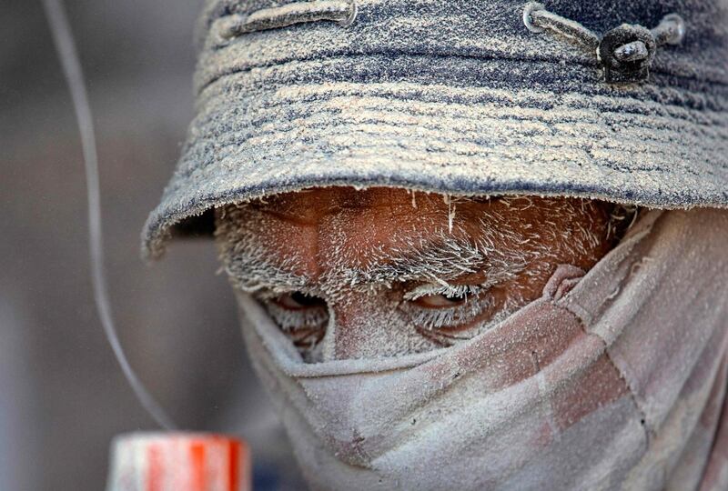 A worker's face is covered in dust as he unloads imported corn at the southern Iraqi port of Umm Qasr near Basra. AFP