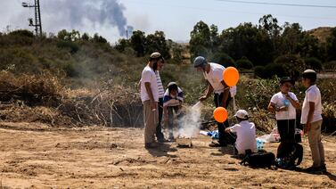 As smoke rises from Gaza, young boys cook food on a barbecue, an Israeli Independence Day tradition. Caitlin Kelly for The National