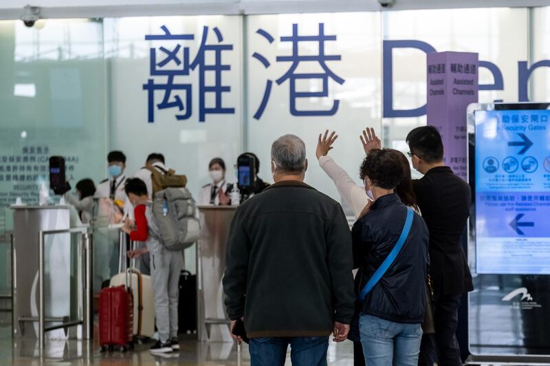 People wave in the departures hall at the Hong Kong International Airport in Hong Kong, China. Bloomberg