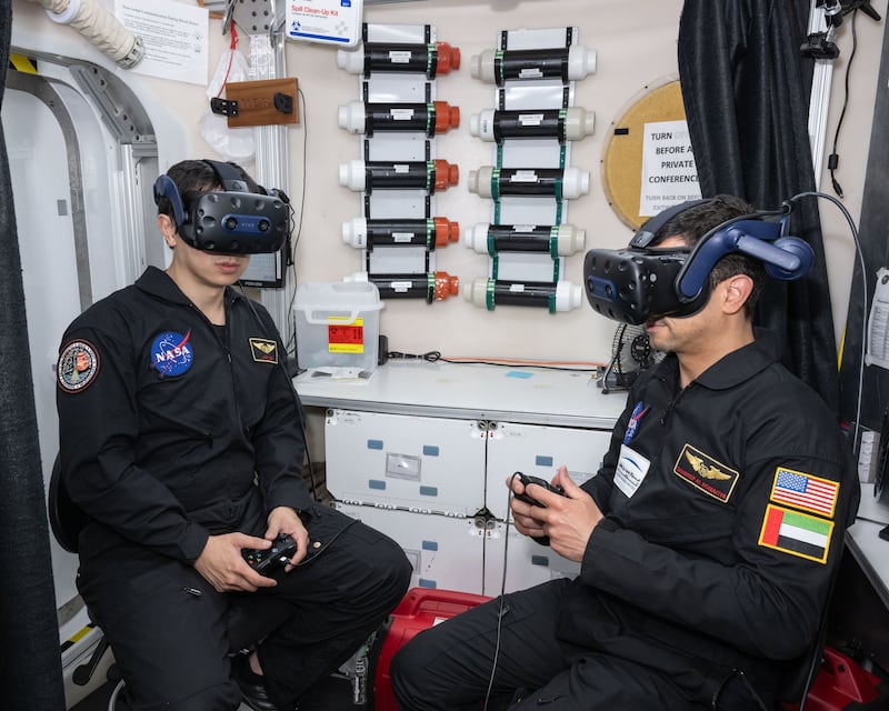 Mr Al Romaithi and a crew mate using headsets to carry out virtual reality walks on the Martian surface. MBRSC