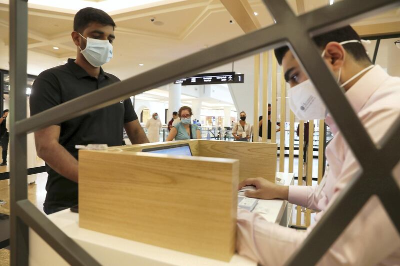 DUBAI, UNITED ARAB EMIRATES , October 14 – 2020 :- Anto Antony (left) taking the token for his COVID-19 nasal swab test at the COVID 19 testing station set up at Mall of the Emirates in Dubai. (Pawan Singh / The National) For News/Online. Story by Sarwat