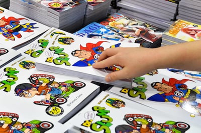 A visitor looks at an Japanese artist Akira Toriyama's Dr.  Slump comic book at the 27th Manga Fair 2021 in Barcelona on October 31, 2021.  (Photo by Pau BARRENA  /  AFP)