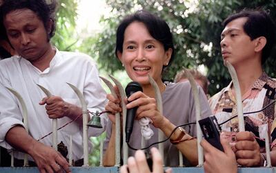 (FILES) In this file photo taken on July 14, 1995, pro-democracy leader Aung San Suu Kyi (C) addresses supporters from the main gate of her family compound in Yangon. Ousted Myanmar leader Aung San Suu Kyi will hear the first testimony against her in a junta court on June 14, 2021, more than four months after a military coup. / AFP / Manny CENETA
