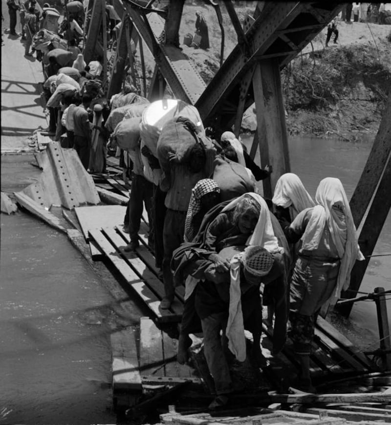 Palestine refugees flee across over the Jordan river on the damaged Allenby Bridge during the 1967 Arab-Israeli war. AP Photo/UNRWA Photo Archives
