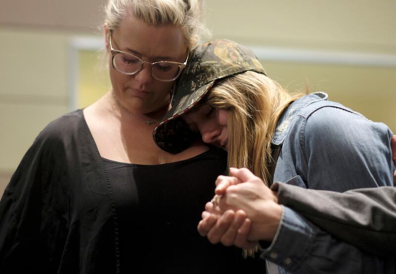 People comfort each other after a candlelight vigil for the victims of the mass shooting. AP Photo