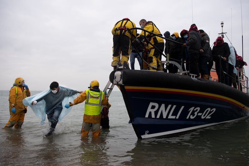 Migrants are helped ashore from a RNLI lifeboat at a beach in Dungeness. Their humanitarian efforts provoke the ire of far-right groups in the UK. AFP