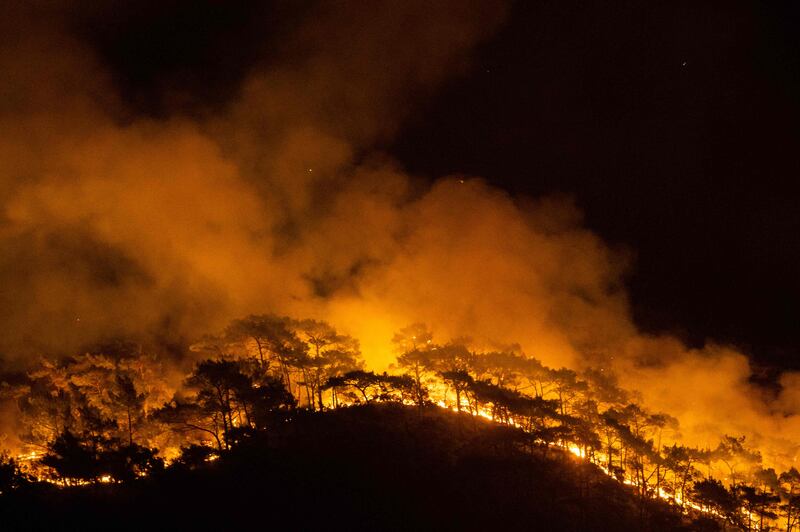 This photograph shows a forest burning as a massive wildfire engulfed a Mediterranean resort at the Marmaris district of Mugla, on August 1 2021.  - At least three people were reported dead on July 29, 2021 and more than 100 injured as firefighters battled blazes engulfing a Mediterranean resort region on Turkey's southern coast.  (Photo by Yasin AKGUL  /  AFP)