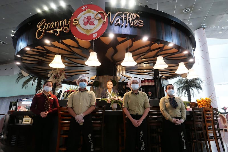 DUBAI, UNITED ARAB EMIRATES , November 11 – 2020 :- Mansour Cheikh El Ard, owner of Granny's Waffles with his staff members at the Dubai Mall in Dubai. He let his tenant to stay rent-free in a villa. Social media post on this caught people's attention and public is trying to support the business. They are getting an increased number of orders. He is from Syria and living in Dubai since 2005. (Pawan Singh / The National) For News/Online/Instagram. Story by Anam