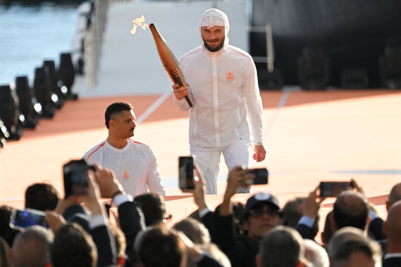 Jul holds the Olympic Torch next to Manaudou during the arrival ceremony. AFP