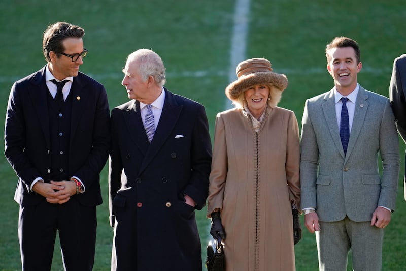 King Charles and Queen Camilla talk to co-owners of Wrexham AFC Ryan Reynolds and Rob McElhenney during a visit to Wales in December 2022