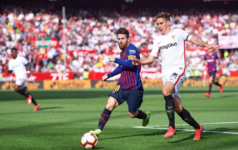 Lionel Messi tussles with Marko Rog of Sevilla. Getty