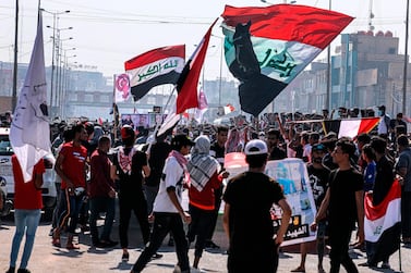 Protesters wave national flags during anti-government protests in Basra, Iraq, on Sunday, October 25, 2020. Thousands of Iraqis have taken to the streets to mark one year since mass anti-government demonstrations swept Baghdad and Iraq’s south. Demonstrators marched on Sunday in Baghdad and several southern cities to renew demands to bring an end to corruption perpetuated by the country’s politicians. AP