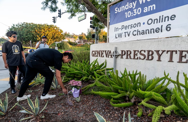 Hector Gomez and Jordi Poblete, worship leaders at the Mariners Church Irvine, leave flowers outside the Geneva Presbyterian Church in Laguna Woods, California. AP