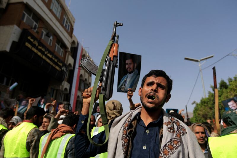 Supporters of Yemen's Houthis raise portraits of their leader Abdul Malik Al Houthi at a rally in Sanaa in June. AFP